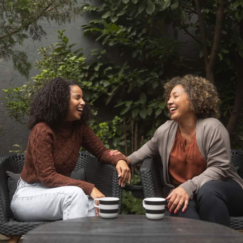 two women sitting and sharing coffee